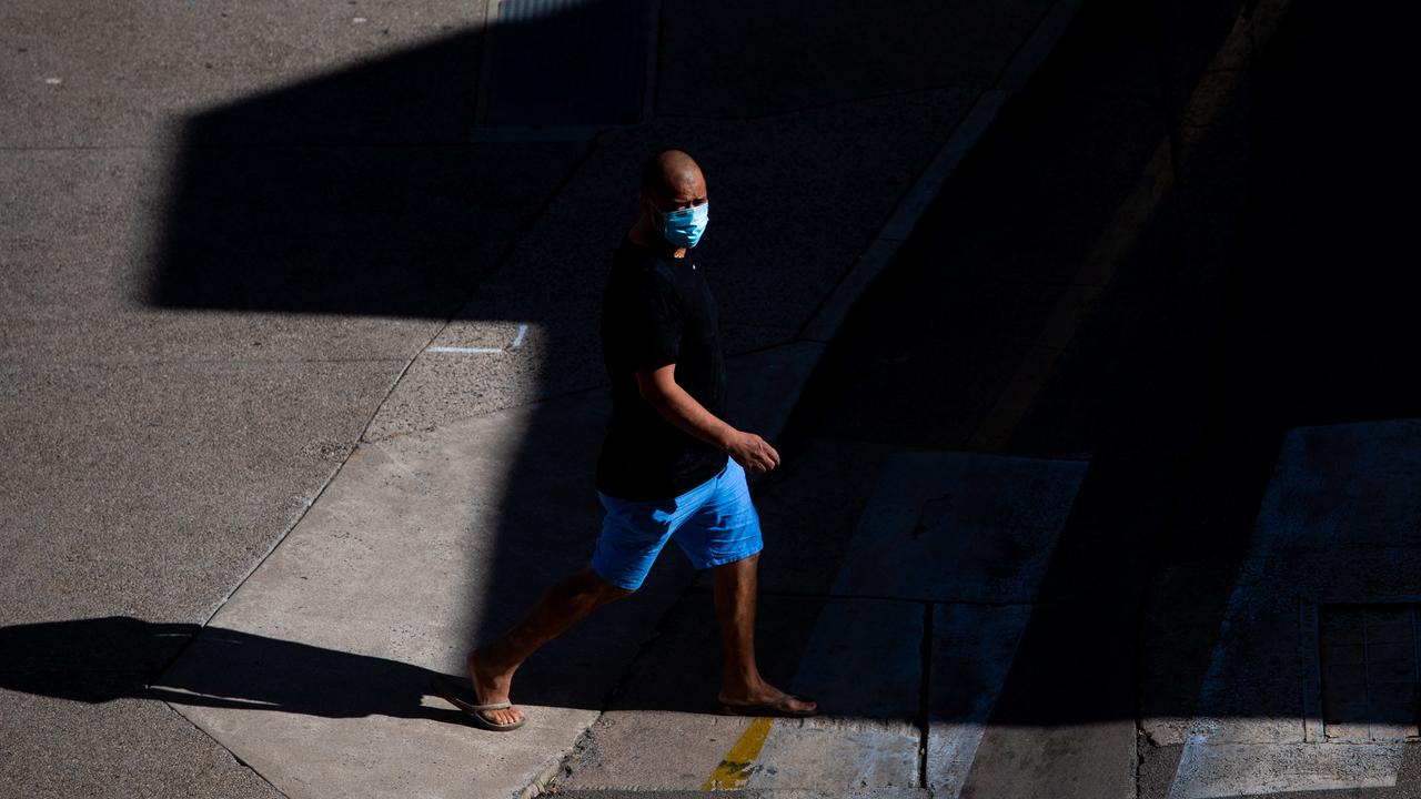 A man walks across an otherwise empty street in the morning light. Picture: Che Chorley