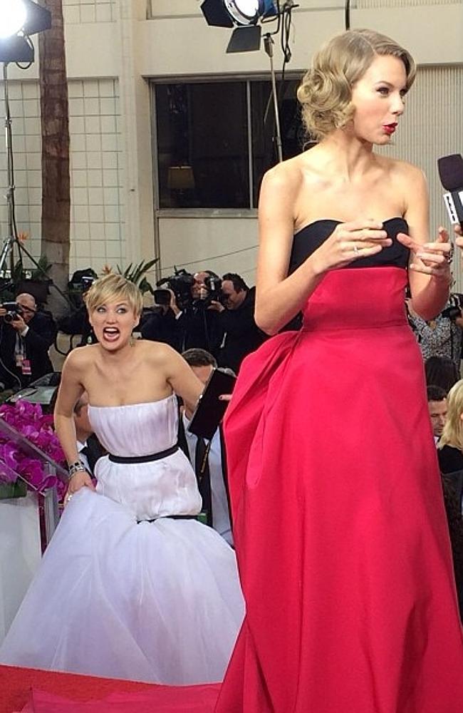 Jennifer Lawrence can’t resist photobombing Taylor Swift during a red carpet interview. 