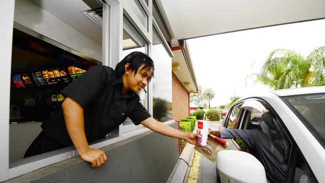 Alice Springs McDonalds staff member Ian Cogollo gives a customer an order at the drive through.