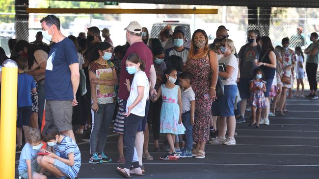 Families lining up at a West Melbourne vaccination clinic. Picture: David Caird