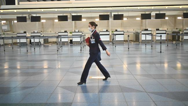 An airline employee in Tokyo's deserted Haneda Airport in March. Picture: AFP