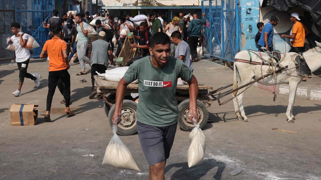 Palestinians storm a UN-run aid supply centre that distributes food to displaced families. Picture: AFP