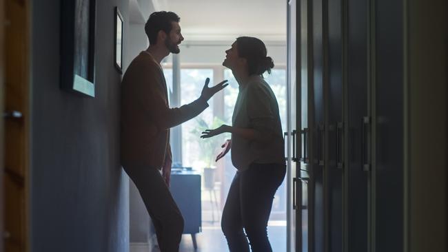 Young Couple Arguing and Fighting. Domestic Violence Scene of Emotional abuse, Stressed Woman and aggressive Man Having Almost Violent Argument in a Dark Claustrophobic Hallway of Apartment.