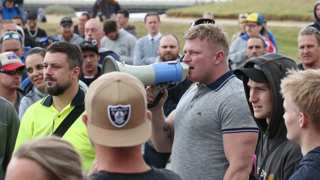 Anti-immigration activists Neil Erikson (yellow shirt) and Blair Cottrell (with megaphone) at St Kilda foreshore. Picture: AAP