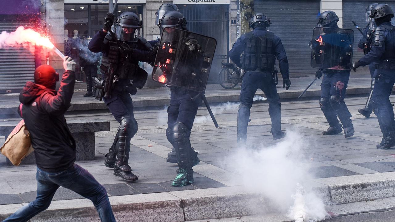 A protester throws a flare at riot police during clashes on the sidelines of a demonstration in Nantes, western France, on March 7, 2023, during a nationwide day of strikes and protests called by unions over the government's proposed pensions reform. Picture: Sebastien Salom-Gomis / AFP