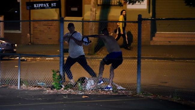 A passer-by walks past the early-morning brawlers. Picture: Gordon McComiskie