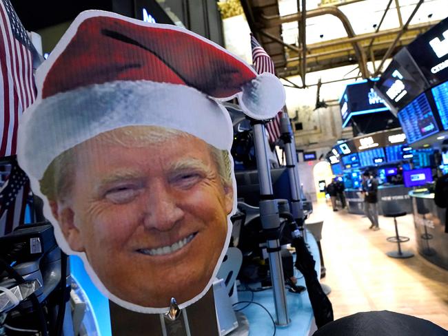 An image of US President-elect Donald Trump is displayed as traders and financial professionals work on the floor of the New York Stock Exchange (NYSE) at the opening bell on November 26, 2024, in New York City. (Photo by TIMOTHY A. CLARY / AFP)