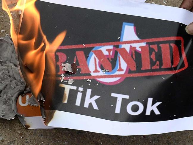 Members of the City Youth Organisation burn posters with the logo of the Chinese owned video-sharing 'Tik Tok' app in support of the Indian government for banning the wildly popular app, in Hyderabad on June 30, 2020. - TikTok on June 30 denied sharing information on Indian users with the Chinese government, after New Delhi banned the wildly popular app citing national security and privacy concerns. "TikTok continues to comply with all data privacy and security requirements under Indian law and have not shared any information of our users in India with any foreign government, including the Chinese Government," said the company, which is owned by China's ByteDance. (Photo by NOAH SEELAM / AFP)