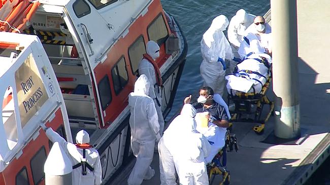 Two sick crew members are brought ashore at Port Botany in Sydney. Picture: 7NEWS