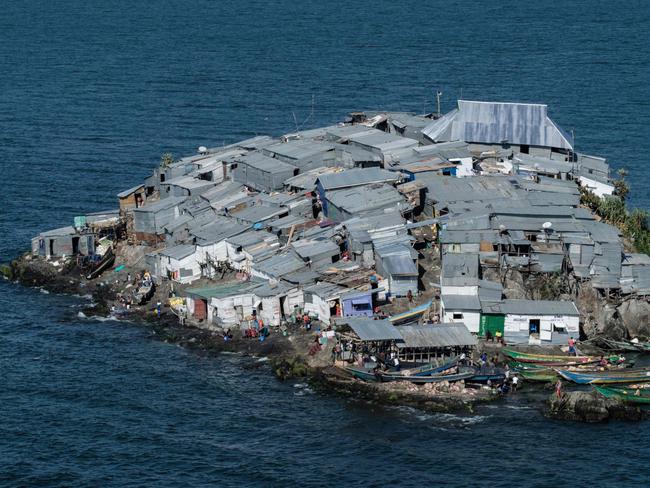 A picture taken on October 5, 2018, shows a general view of Migingo island which is densely populated by residents fishing mainly for Nile perch in Lake Victoria on the border of Uganda and Kenya. - A rounded rocky outcrop covered in metallic shacks, Migingo Island rises out of the waters of Lake Victoria like an iron-plated turtle. The densely-populated island is barely a quarter of a hectare large, its residents crammed into a hodge-podge of corrugated-iron homes, with seemingly little but a few bars, brothels and a tiny port to boast of. (Photo by Yasuyoshi CHIBA / AFP)