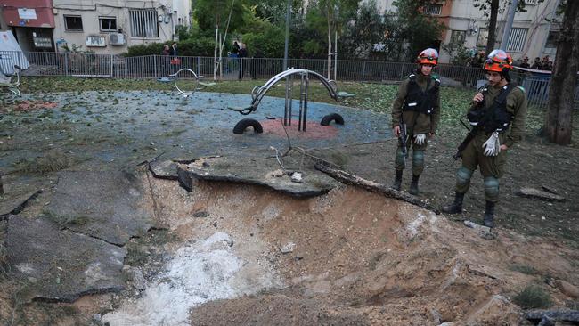 Israeli emergency responders inspect a crater at the site where a projectile fired from Yemen landed, in Tel Aviv. Picture: AFP