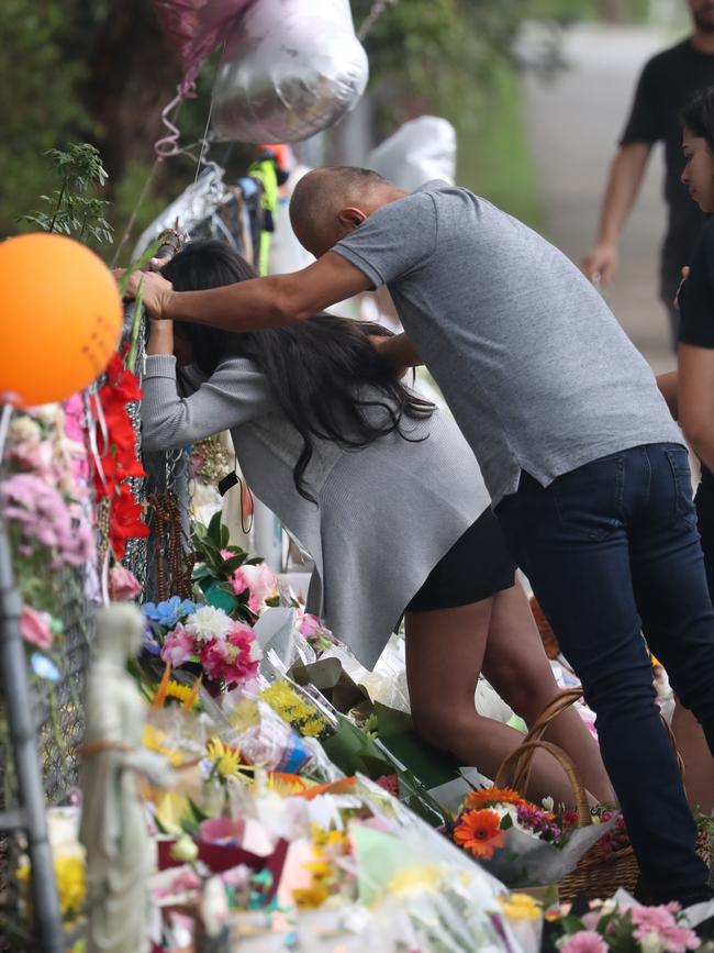 The grieving mother is supported by family on Monday. Picture: John Grainger