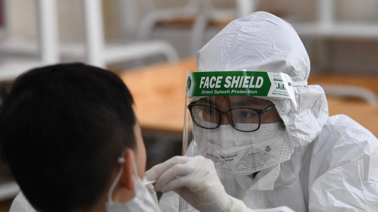 A health worker wearing personal protective equipment (PPE) conducts a Covid-19 coronavirus swab test on a student at the Vinschool private school in Hanoi on May 22, 2021. Picture: Nhac Nguyen / AFP