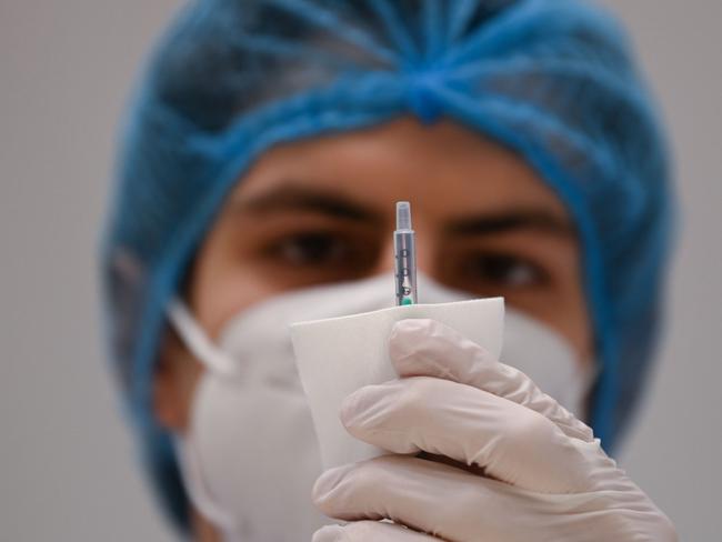 A health care work prepares a syringe filled with the AstraZeneca COVID-19 vaccine in Stuttgart, southern Germany on March 19, 2021. (Photo by Marijan Murat / POOL / AFP)