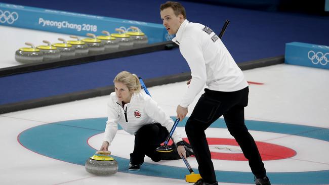 Norway's Kristin Skaslien, left, throws the stone as teammate Magnus Nedregotten looks on during the mixed doubles bronze medal curling match. Photo: AP