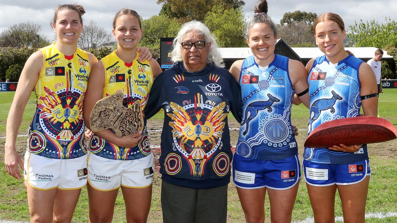 The exchange of gifts between Crows Chelsea Randall and Danielle Ponter and North’s Emma Kearney and Mia King with Aunty Patty. Picture: Sarah Reed
