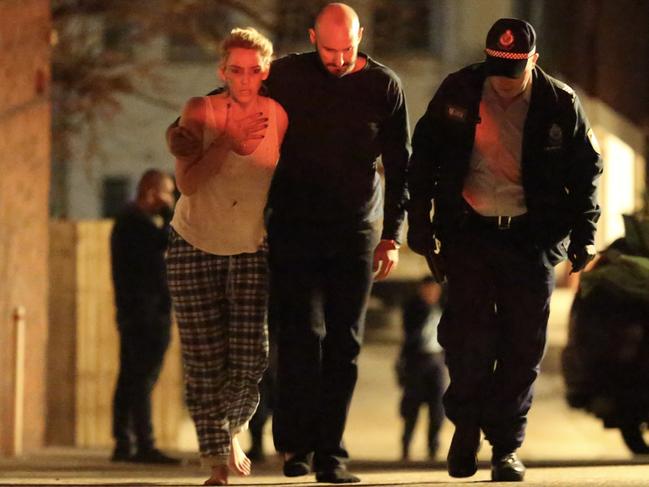 A woman is consoled outside the apartment block on Military Rd in North Bondi after the stabbing.