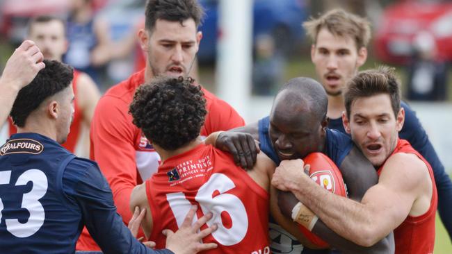 South's Emmanuel Irra tries to crash through a wall of North Adelaide players. Picture: AAP/Brenton Edwards