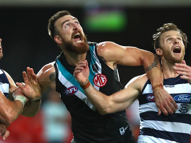 GOLD COAST, AUSTRALIA - AUGUST 14: Charlie Dixon of the Power (center) is wrapped up by Geelong defense during the round 12 AFL match between the Geelong Cats and the Port Adelaide Power at Metricon Stadium on August 14, 2020 in Gold Coast, Australia. (Photo by Jono Searle/AFL Photos/via Getty Images)