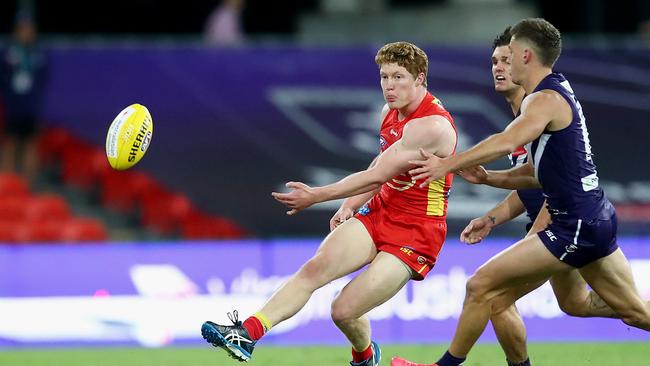 GOLD COAST, AUSTRALIA – JUNE 27: Matthew Rowell of the Suns kicks the ball during the round 4 AFL match between the Gold Coast Suns and Fremantle Dockers at Metricon Stadium on June 27, 2020 in Gold Coast, Australia. (Photo by Jono Searle/AFL Photos/via Getty Images )