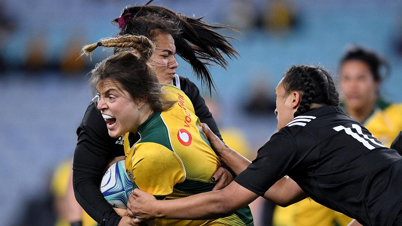 Grace Hamilton of the Wallaroos is tackled by Stacey Waaka and Ruahei Demant.