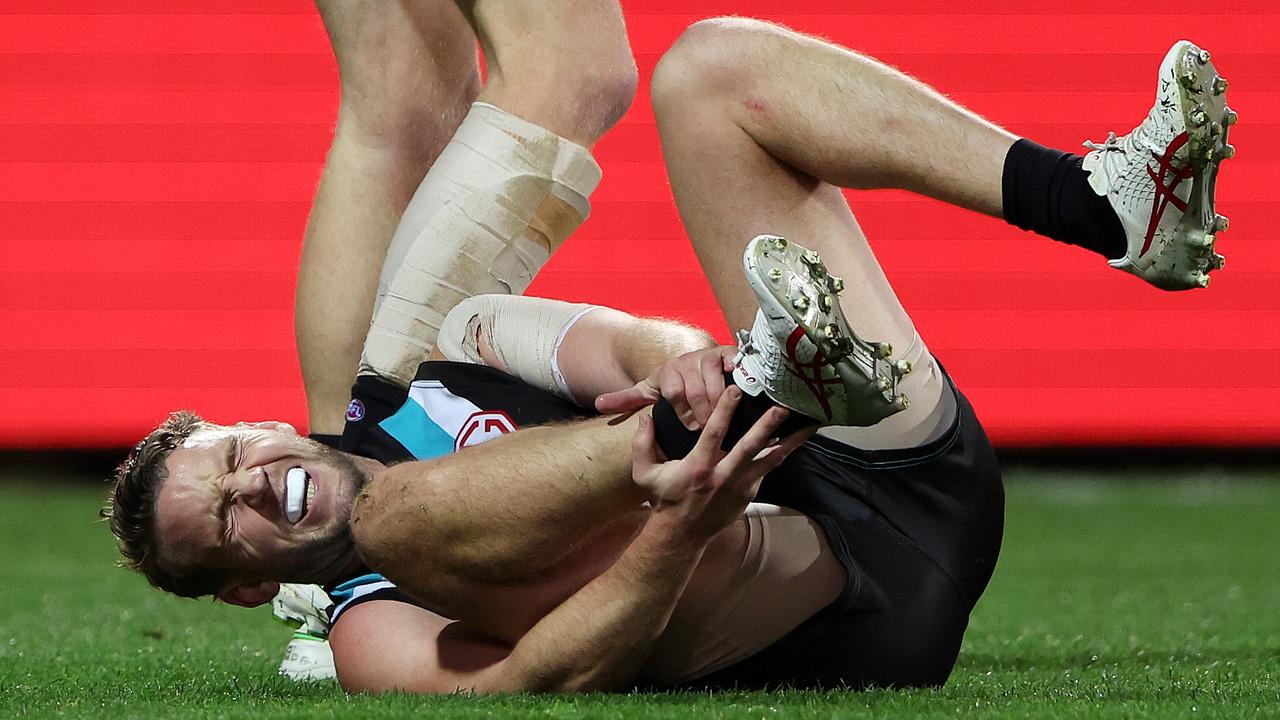 ADELAIDE, AUSTRALIA – JULY 08: Trent McKenzie of the Power grabs his ankle after getting hurt in a marking contest with Levi Casboult of the Suns mduring the 2023 AFL Round 17 match between the Port Adelaide Power and the Gold Coast Suns at Adelaide Oval on July 8, 2023 in Adelaide, Australia. (Photo by Sarah Reed/AFL Photos via Getty Images)