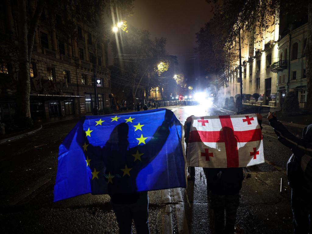 Demonstrators hold up a European Union and a Georgian flag on the fifth night of protests. Picture: Giorgi ARJEVANIDZE / AFP