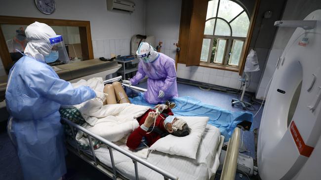 A patient infected by the COVID-19 coronavirus prepares for a CT scan at the Red Cross hospital in Wuhan. Picture: AFP