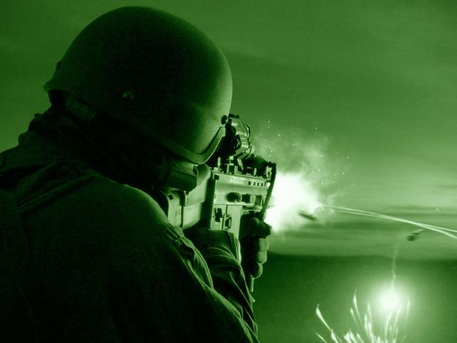 Night vision of a special operations forces soldier firing his weapon during combat.