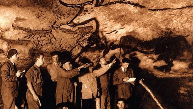 Supplied Editorial History: Marcel Ravidat (seated right) shows people through the Lascaux cave in 1940