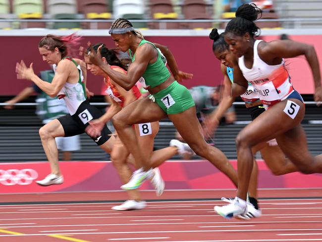 Krystsina Tsimanouskaya (left, in white and black) competes in the women's 100m heats during the Tokyo 2020 Olympic Games. Picture: AFP