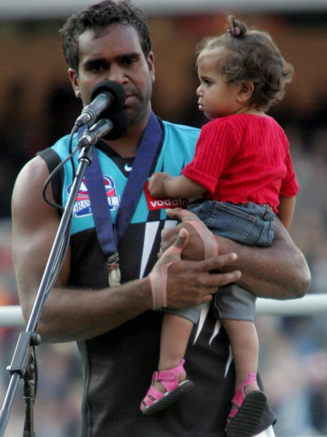 Port Adelaide’s Byron Pickett with daughter Lakeesha accepting the Norm Smith medal after the 2004 grand final at the MCG.