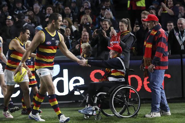 Adelaide Crows co-captain Taylor Walker slaps hands with a Crows supporter as he runs out for Showdown 46 at Adelaide Oval. Picture Sarah Reed