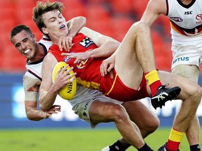 Charlie Ballard of the Suns takes a mark as he is tackled by Lachlan Murphy. Picture: AAP / Dave Hunt