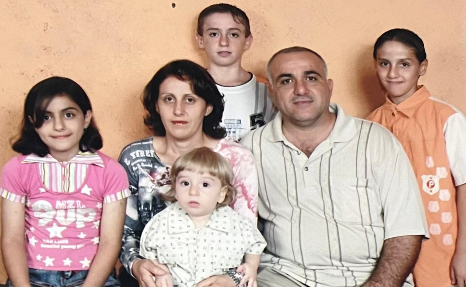 Frans Deli on the lap of his mother Maisoon Tourani with his father Farid Dally and siblings just after they arrived in Australia. Picture: Supplied