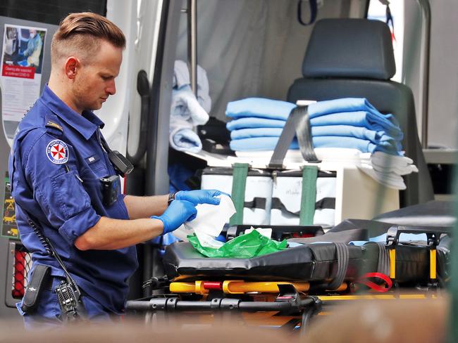 SUNDAY TELEGRAPH - 26/3/20Ambulance officers clean down the vehicle after transporting patients to RPA in Camperdown today. Picture: Sam Ruttyn