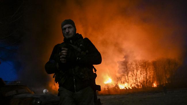 A Ukrainian serviceman in front of a burning warehouse after a shelling in Kyiv. Picture: AFP