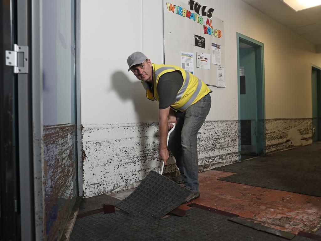 University of Tasmania maintenance worker Greg Chandler cleaning up destroyed carpet tiles in the law faculty Picture: LUKE BOWDEN