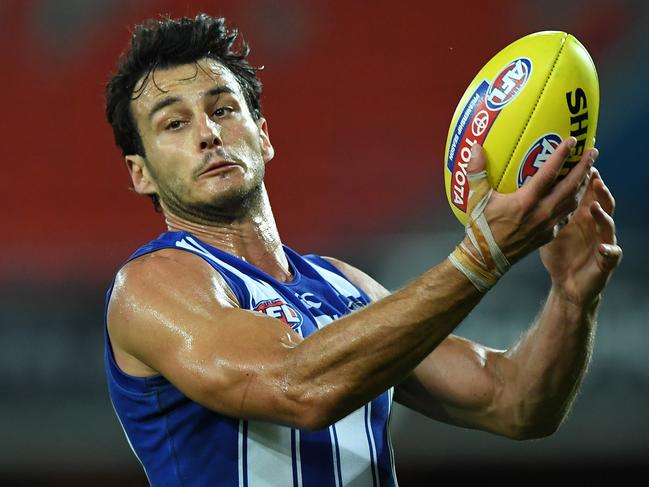 GOLD COAST, AUSTRALIA - SEPTEMBER 05: Robbie Tarrant of the Kangaroos handballs during the round 16 AFL match between the North Melbourne Kangaroos and the Port Adelaide Power at Metricon Stadium on September 05, 2020 in Gold Coast, Australia. (Photo by Matt Roberts/AFL Photos/via Getty Images)