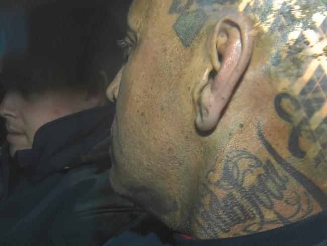 A camera shy Toby Mitchell arrives in a police detectives car at the Melbourne Magistrates court. Picture: Nicole Garmston **exclusive**