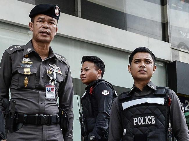 Thai police stand by after disposing of a suspicious bag during a false bomb scare in the tourist-heavy Ratchaprasong district in Bangkok on August 18, 2016. Thailand's junta said more than a dozen suspects are being detained at military barracks on suspicion of launching a string of deadly bomb and arson attacks against tourist resort towns last week. / AFP PHOTO / LILLIAN SUWANRUMPHA