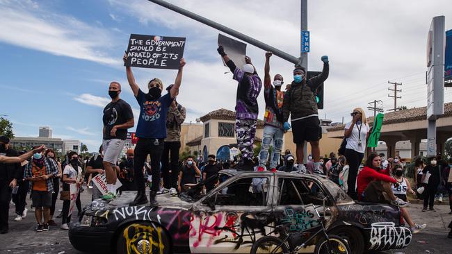 Demonstrators jump on a damaged police vehicle in Los Angeles in 2020, in during a protest against the death of George Floyd. Picture: Ariana Drehsler/AFP