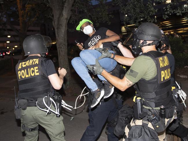 A protester is taken into custody by Atlanta police during a demonstration in Atlanta. Picture: AP