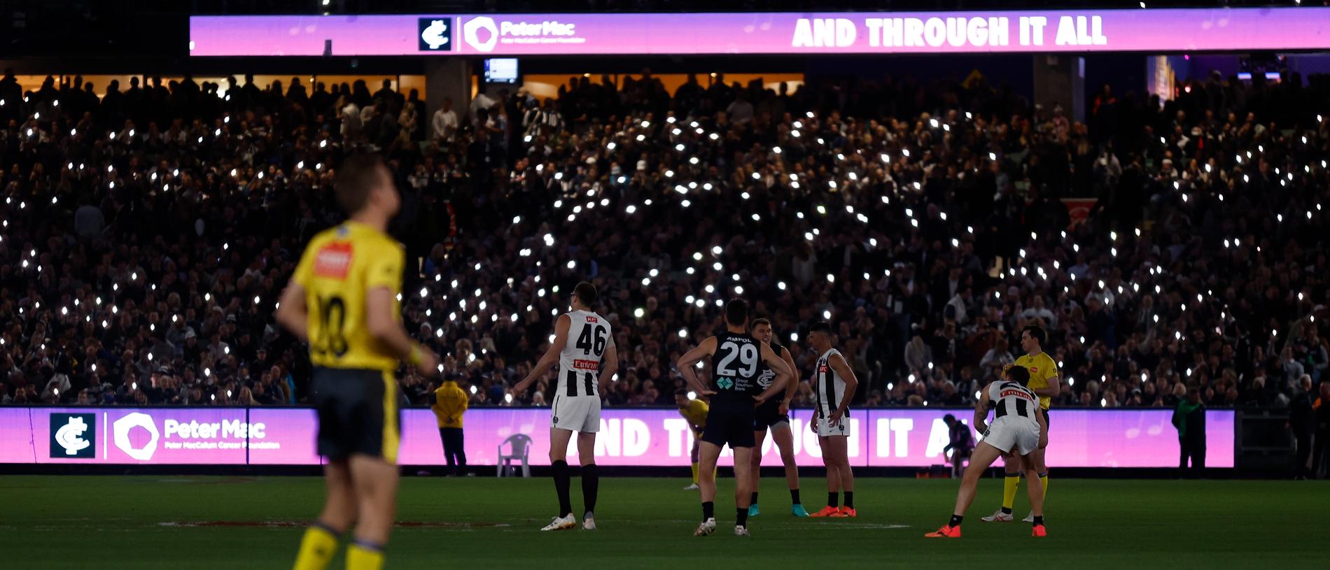 MELBOURNE, AUSTRALIA - MAY 03: The MCG lights up to the tune of Angels by Robbie Williams, honouring all those who are currently battling cancer, and those who have lost their fight before the 2024 AFL Round 08 match between the Carlton Blues and the Collingwood Magpies at The Melbourne Cricket Ground on May 03, 2024 in Melbourne, Australia. (Photo by Michael Willson/AFL Photos via Getty Images)