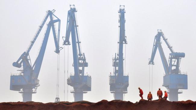 Workers unload ore from Australia at a port in Tianjin. Picture: Reuters