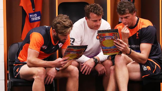 Callan Ward (left) reads the footy record before taking on Brisbane. Picture: Phil Hillyard