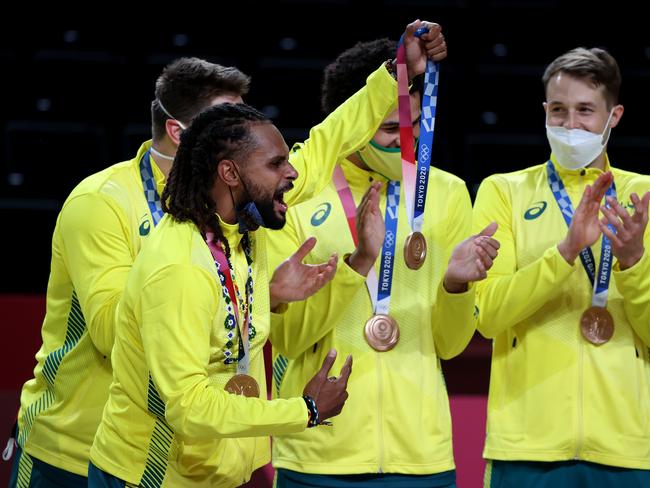 Patty Mills celebrates with his bronze medal in Tokyo.