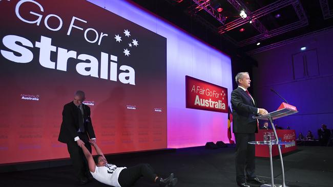 A woman protesting treatment of asylum seekers is removed from the stage during Labor’s national conference on Sunday in Adelaide. Picture: AAP / Lukas Coch