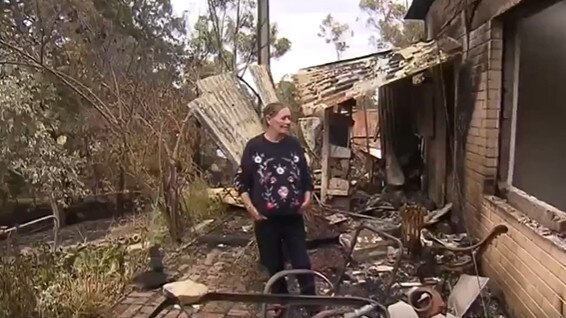 Rae Townsend looks over the ruins of her home.