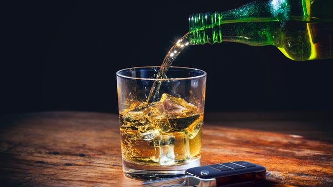 Drinking and driving concept. Car key and whiskey  glass and bottle on a wooden bar counter background. 3d illustration. Picture: iStock/Rawf8